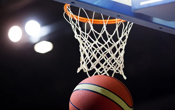 Basquete passando pelo aro em uma arena de esportes — Fotografia de Stock