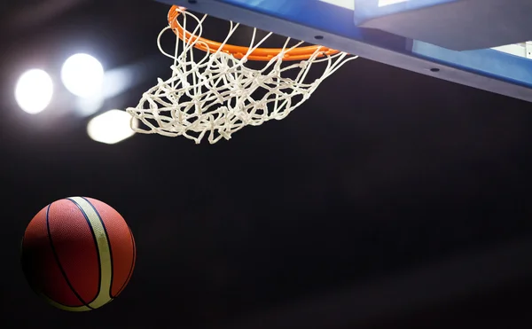 Basketball going through the hoop at a sports arena — Stock Photo, Image