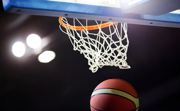 Баскетбол, що проходить через кільце на спортивній арені — стокове фото