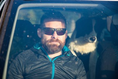 Adam ve köpeği arabayla seyahat ediyorlar.