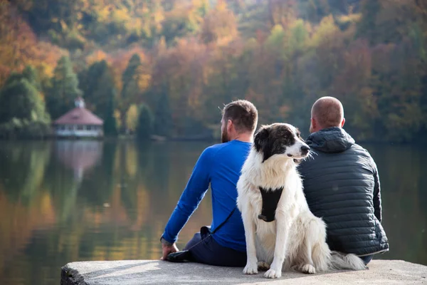 Dos Hombres Perro Sentado Junto Lago Otoño — Foto de Stock