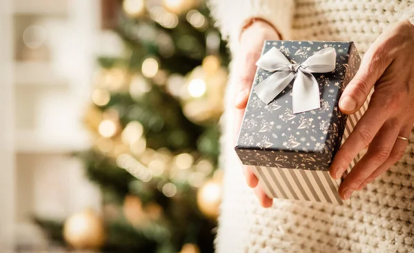 Mão Segurando Caixa Presente Natal Frente Luzes Férias — Fotografia de Stock