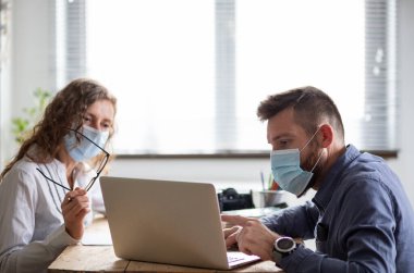 İş ekibi maske takarak birlikte çalışıyor.