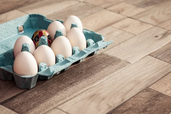 white eggs in box and traditional painted easter eggs from Bucovina region, Romania