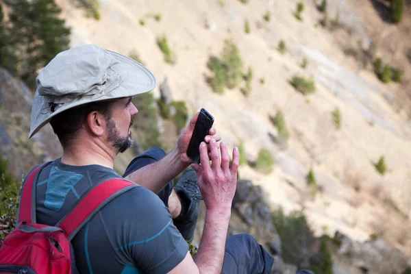 Чоловічий Пішохід Сидить Вершині Гори Захоплюючись Видом Фотографує Смартфоном — стокове фото