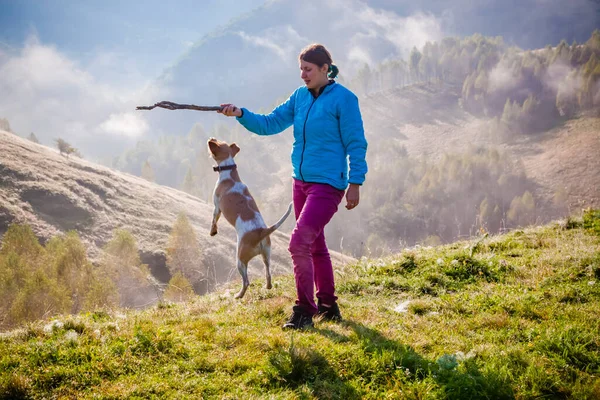 女人和她的狗在美丽的山景中玩耍 — 图库照片