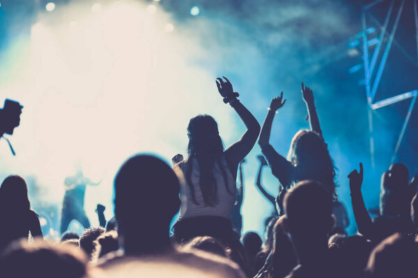 cheering crowd with raised hands at concert - music festival