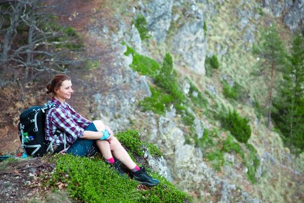 女徒步旅行者坐在山顶上欣赏风景 — 图库照片