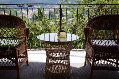 Teras, masa ve dağlara bakan ahşap sandalyeler.