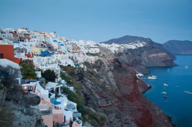 Yunanistan 'ın Santorini adasındaki güzel Oia kasabası. Geleneksel beyaz mimari ve Caldera, Ege denizi üzerinde mavi kubbeli Yunan ortodoks kiliseleri, Manzaralı seyahat geçmişi