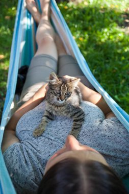 Kadın kedisiyle rahatlıyor.