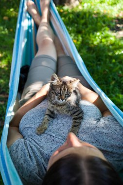 Kadın kedisiyle rahatlıyor.