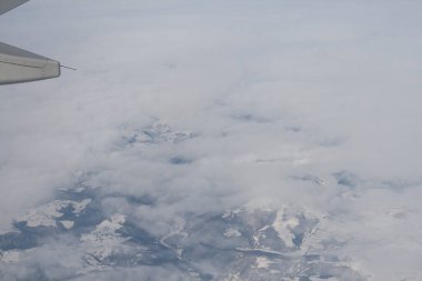 Bulutlar ve gökyüzü bir uçağın penceresinden görüldüğü gibi