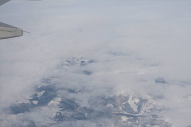 Bulutlar ve gökyüzü bir uçağın penceresinden görüldüğü gibi