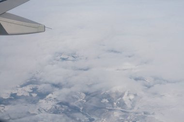 Bulutlar ve gökyüzü bir uçağın penceresinden görüldüğü gibi
