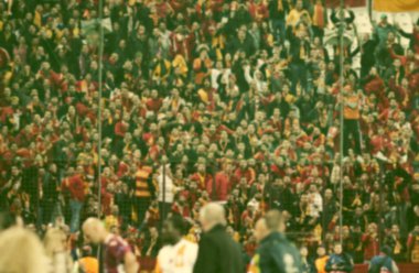 Stadyumdaki futbol taraftarlarının kalabalığı - odaklanmış arka plan - futbol kavramı