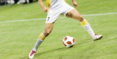 Futbolcular sahada futbol oynuyor.