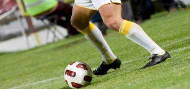 Futbolcular sahada futbol oynuyor.