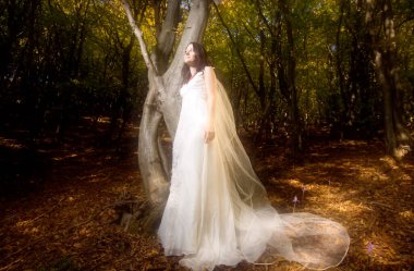 Parkta beyaz elbiseli güzel bir gelin.