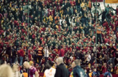 Stadyumdaki futbol taraftarlarının kalabalığı - odaklanmış arka plan - futbol kavramı