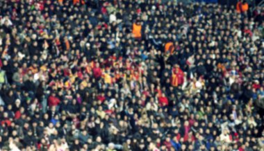 Stadyumdaki futbol taraftarlarının kalabalığı - odaklanmış arka plan - futbol kavramı