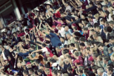 Stadyumdaki futbol taraftarlarının kalabalığı - odaklanmış arka plan - futbol kavramı