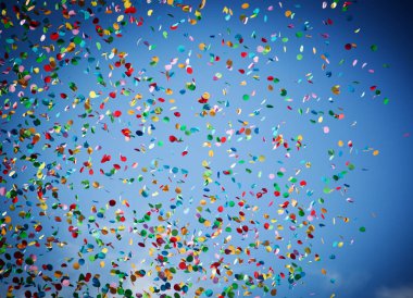 Şehir festivalinde mavi gökyüzü arka planında düşen konfeti