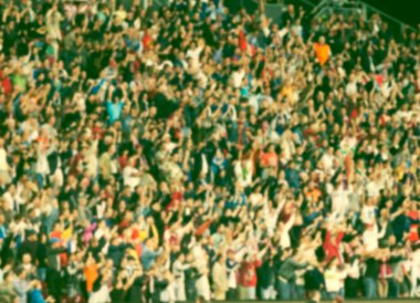 Stadyumdaki futbol taraftarlarının kalabalığı - odaklanmış arka plan - futbol kavramı