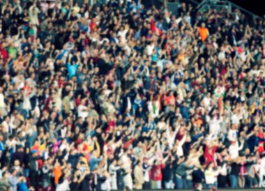 Stadyumdaki futbol taraftarlarının kalabalığı - odaklanmış arka plan - futbol kavramı