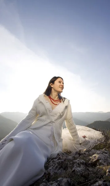美丽的新娘穿着白衣在山上 — 图库照片