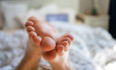 Evde dizüstü bilgisayarı olan bir adam var.