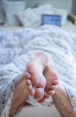 Evde dizüstü bilgisayarı olan bir adam var.