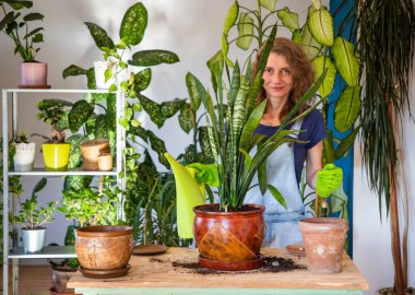 Evin içine çiçek eken kadın bahçe işleriyle uğraşıyor.