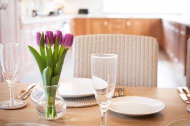 Parlak mutfakta laleleri olan bir masa.