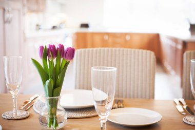 Parlak mutfakta laleleri olan bir masa.