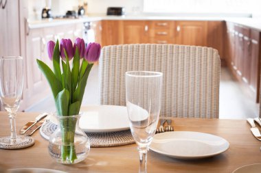 Parlak mutfakta laleleri olan bir masa.