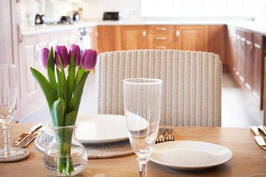 Parlak mutfakta laleleri olan bir masa.