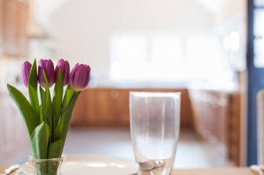 Parlak mutfakta laleleri olan bir masa.