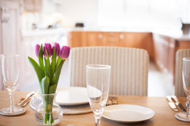 Parlak mutfakta laleleri olan bir masa.