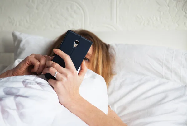 beautiful woman using smartphone in bed