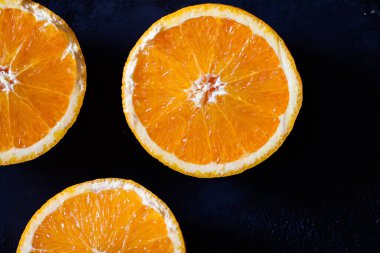 taze organik portakallar ve siyah arka planda meyve suyu.