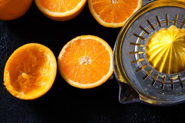 taze organik portakallar ve siyah arka planda meyve suyu.