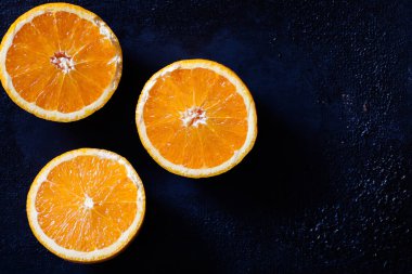 taze organik portakallar ve siyah arka planda meyve suyu.