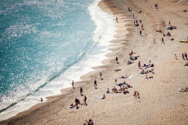 İnsanlar Dorset, İngiltere 'nin Jurassic Sahili' ndeki güzel bir kumsalda sıcak bir yaz gününün tadını çıkarıyorlar.