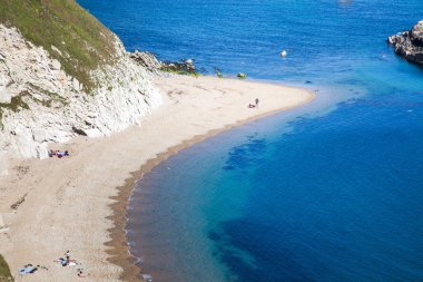 İnsanlar Dorset, İngiltere 'nin Jurassic Sahili' ndeki güzel bir kumsalda sıcak bir yaz gününün tadını çıkarıyorlar.