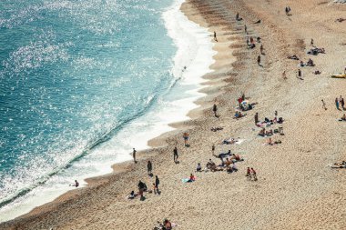 İnsanlar Dorset, İngiltere 'nin Jurassic Sahili' ndeki güzel bir kumsalda sıcak bir yaz gününün tadını çıkarıyorlar.