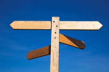 Mavi gökyüzüne karşı boş tahta tabela