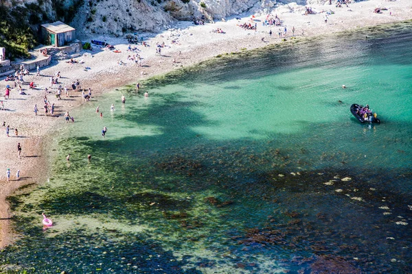 people enjoying a hot summer day on a beautiful hidden beach on the Jurassic Coast of Dorset, UK - Britiish summer holiday destination