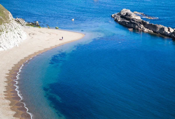 people enjoying a hot summer day on a beautiful hidden beach on the Jurassic Coast of Dorset, UK - Britiish summer holiday destination