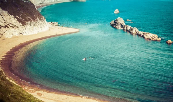 people enjoying a hot summer day on a beautiful hidden beach on the Jurassic Coast of Dorset, UK - Britiish summer holiday destination